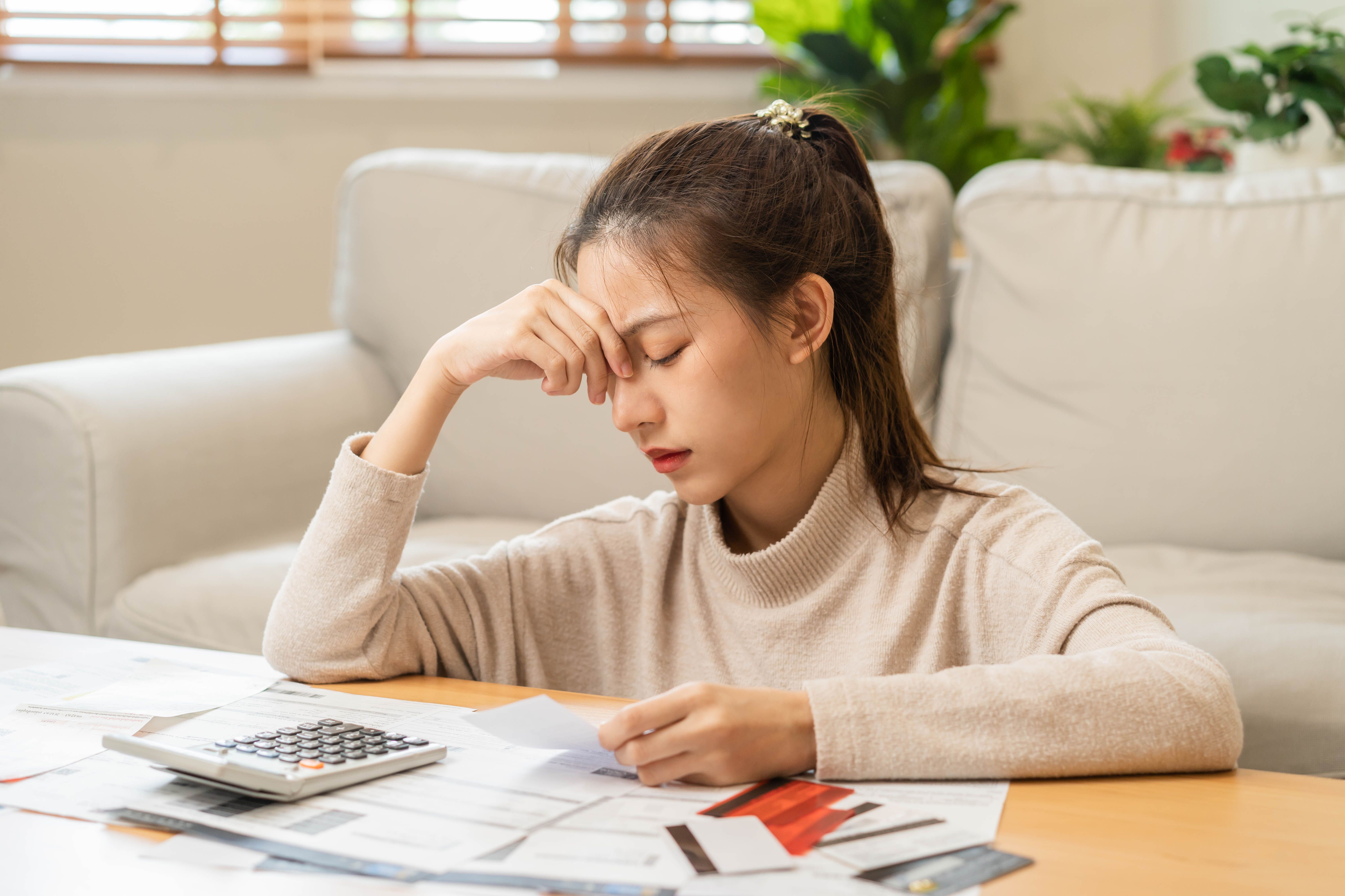 Young woman looking concerned while reviewing a credit card bill or statement